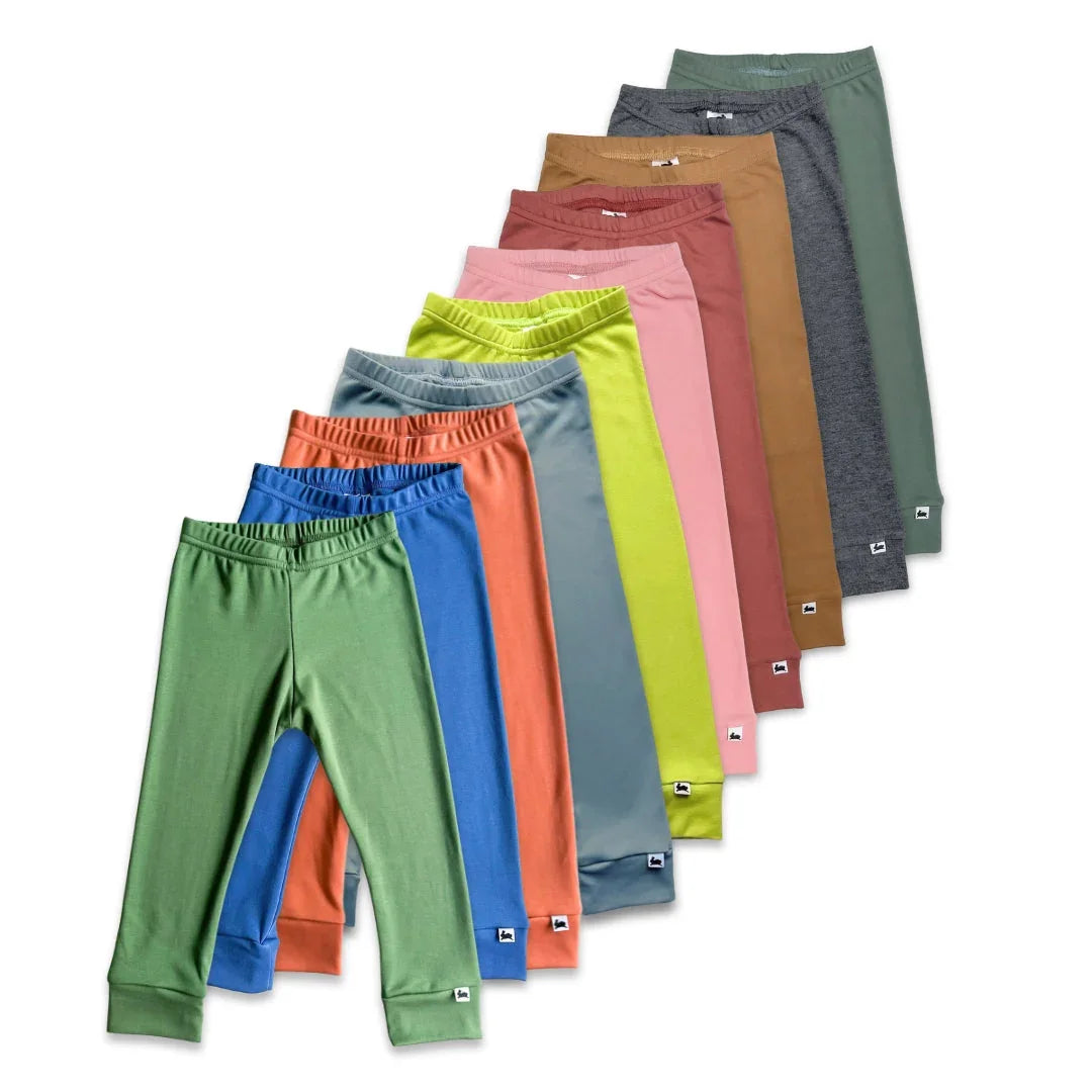 Colorful kids leggings in solid colors arranged in a row on a white background