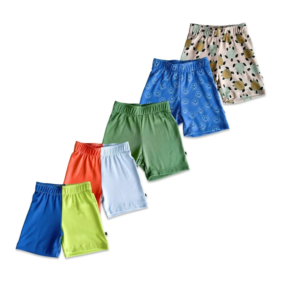 Assorted kids classic shorts in solid colors and playful prints on white background