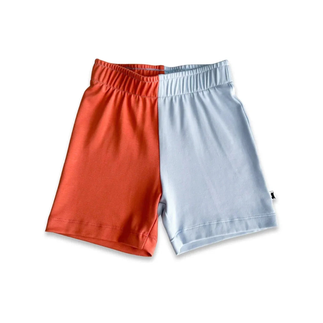 Two-tone shorts with elastic waist, half orange and half light blue, on white background