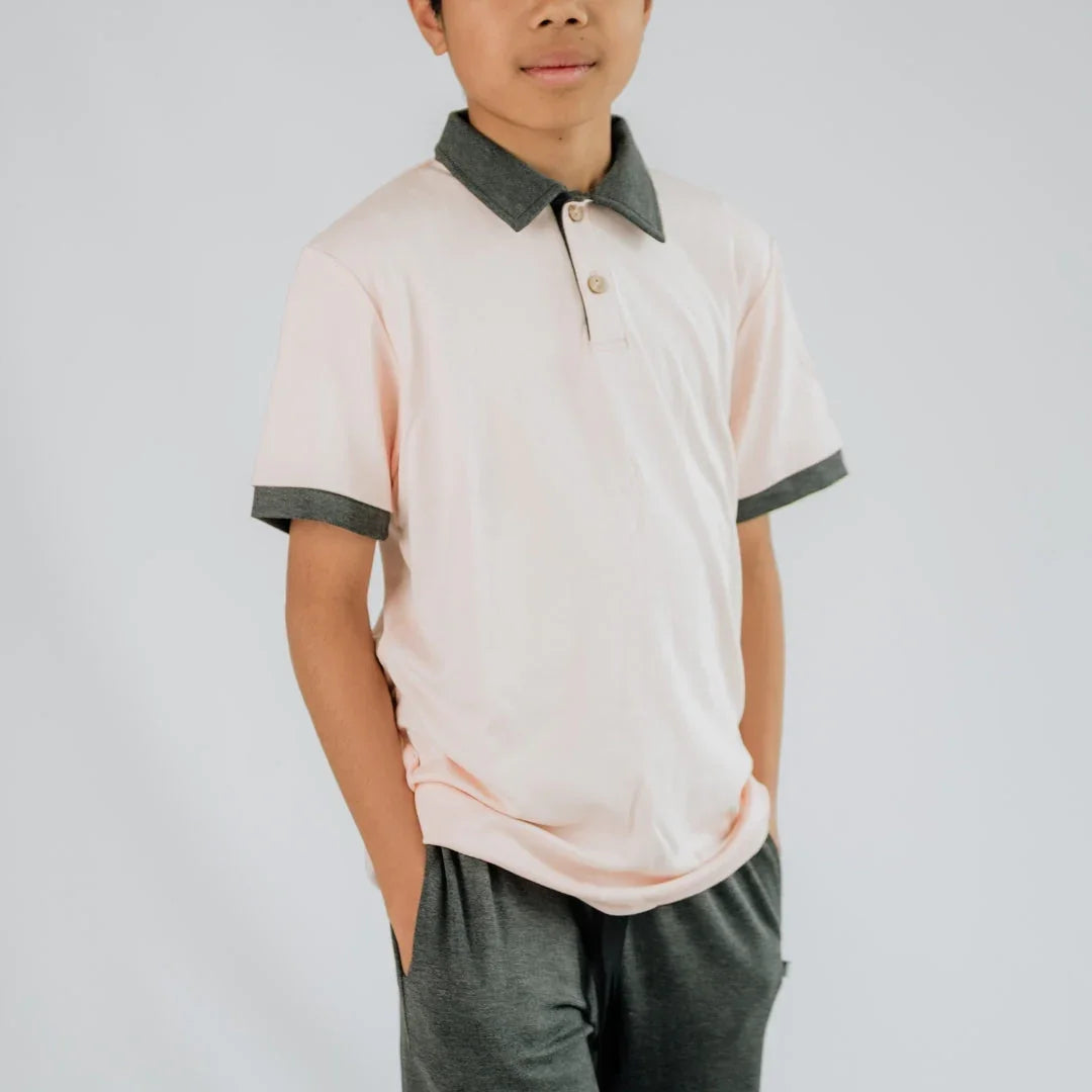 Youth wearing light pink polo shirt with dark gray collar and cuffs, gray shorts