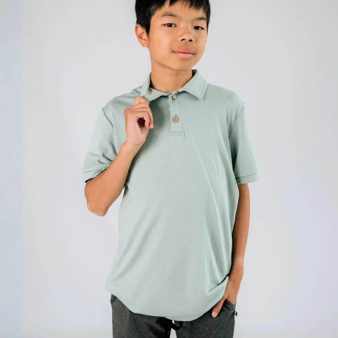 Youth in light green polo shirt with wooden buttons, casual kids clothing on white background