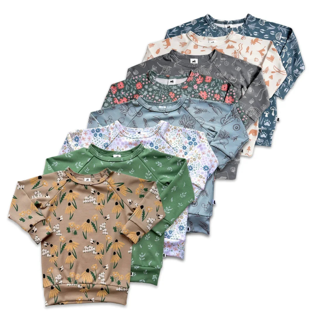 Assorted kids pullover sweatshirts with floral and animal print designs on white background