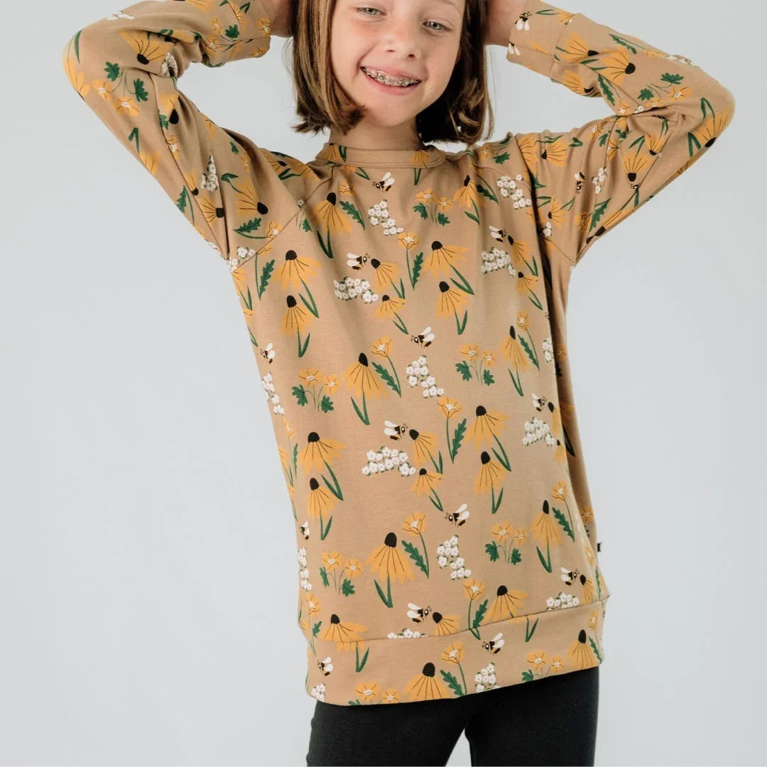 Youth wearing tan floral print pullover with yellow flowers and bees, front view