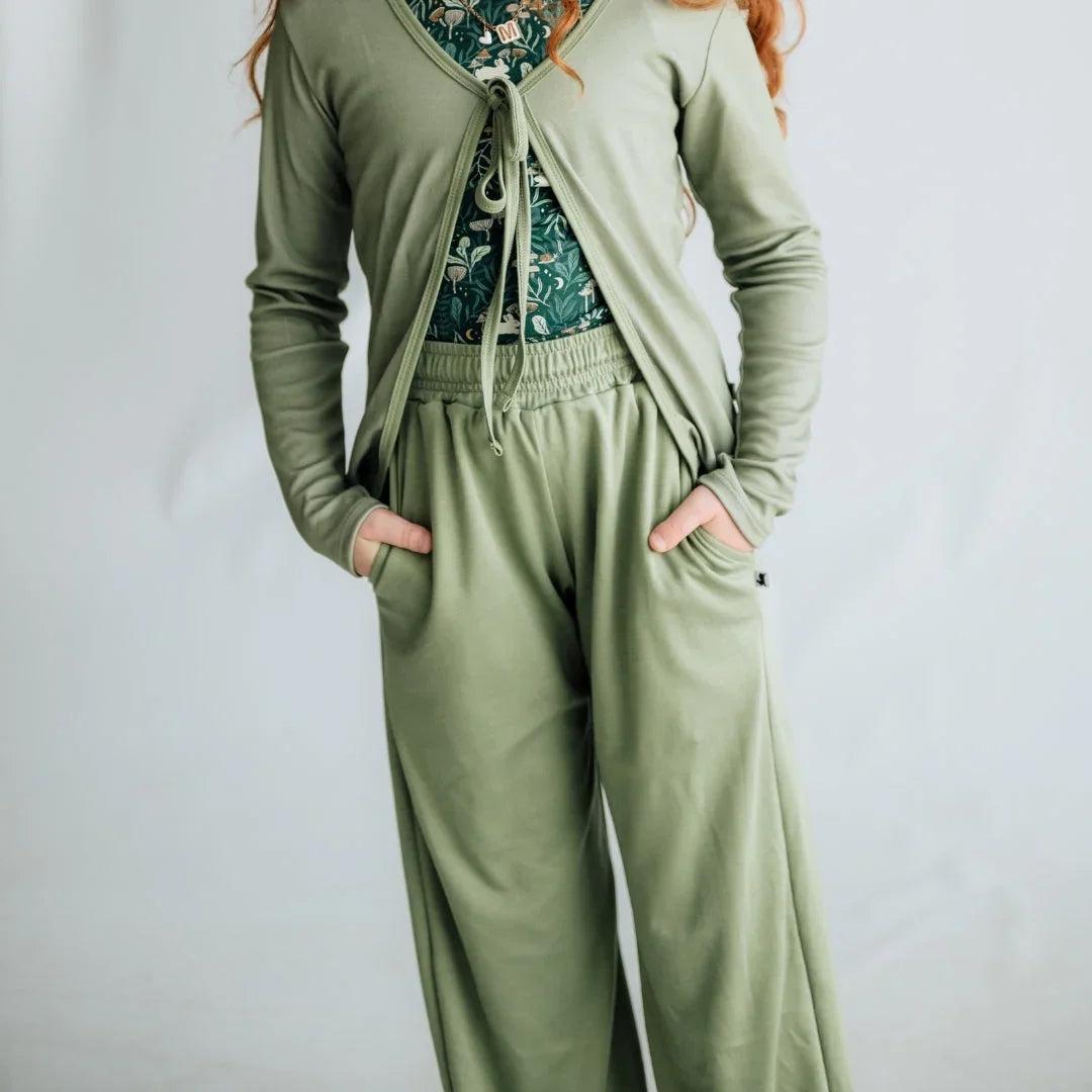 Girl wearing sage green lounge set with printed top and wide-leg pants, hands in pockets