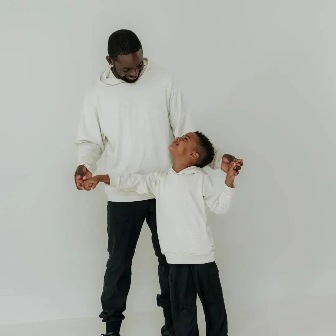 Father and son wearing matching lightweight bamboo hoodies, standing indoors on a white background.