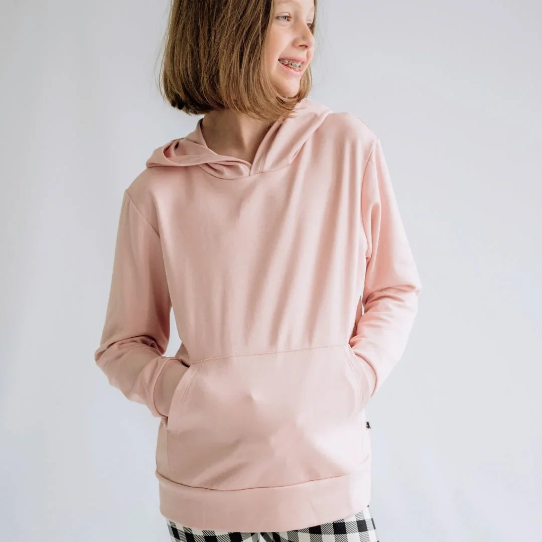 Youth wearing light pink lightweight hoodie with front pocket and plaid pants