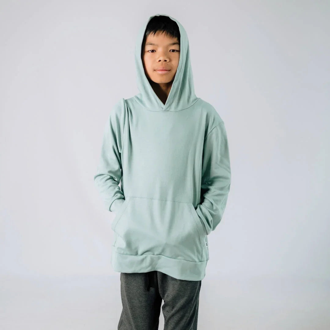 Youth wearing light green lightweight hoodie with front pocket and hood, studio background.