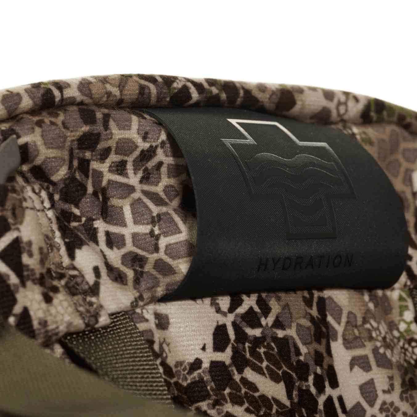 Close-up of camouflage Badlands 2200 backpack hydration sleeve with black logo patch