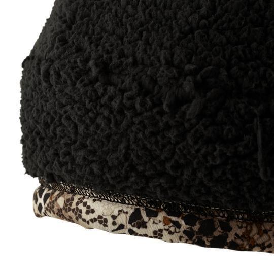 Close-up of black sherpa fleece beanie with brown camo trim, outdoor winter hat