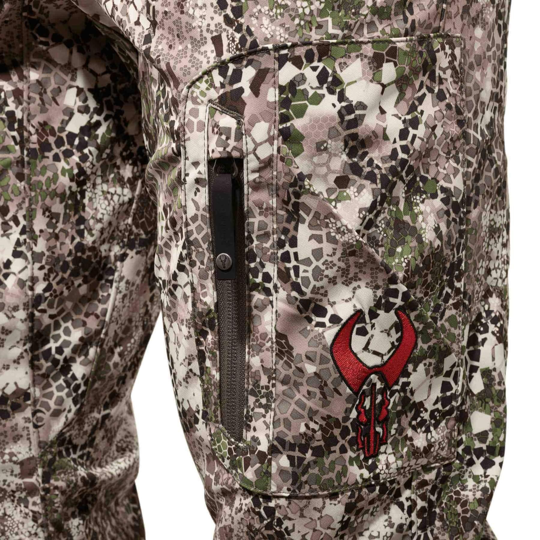 Badlands Ion X camo pants close-up with side zipper pocket and red embroidered logo