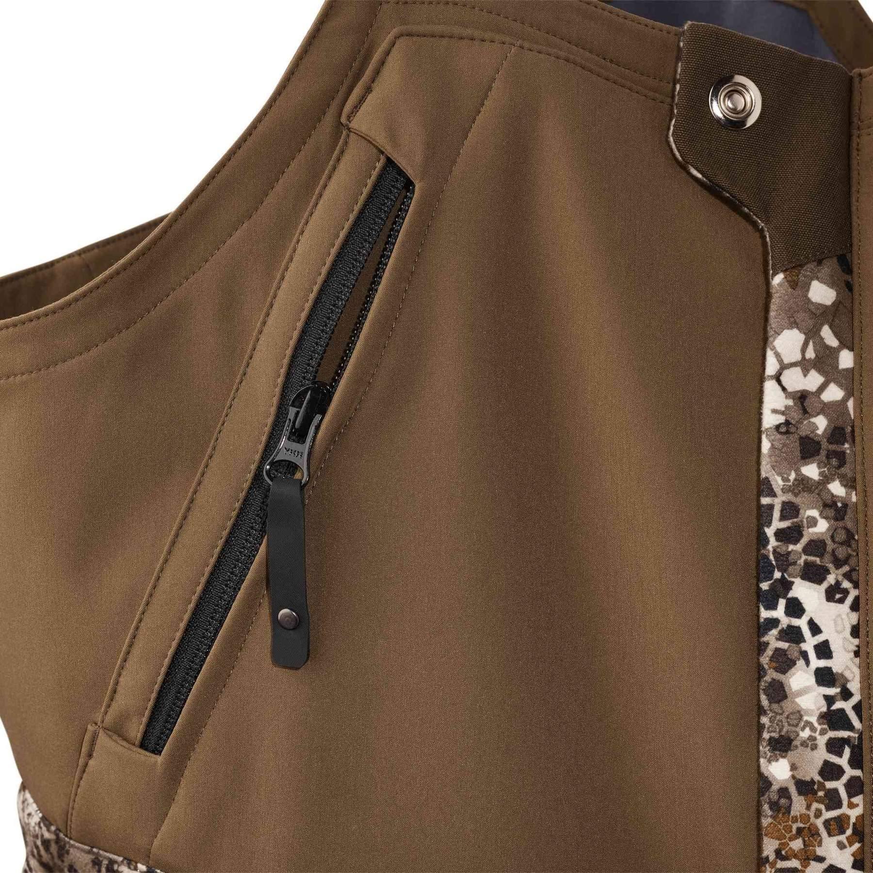 Close-up of Badlands Pyre Bib in brown with camo trim and zippered chest pocket