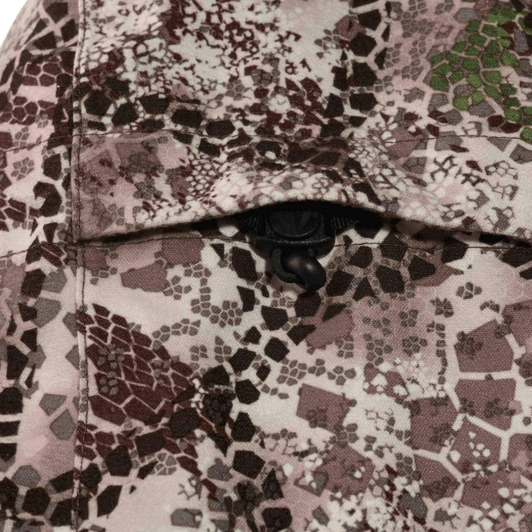 Closeup of Badlands Pyre Jacket pocket with camouflage pattern and cord lock