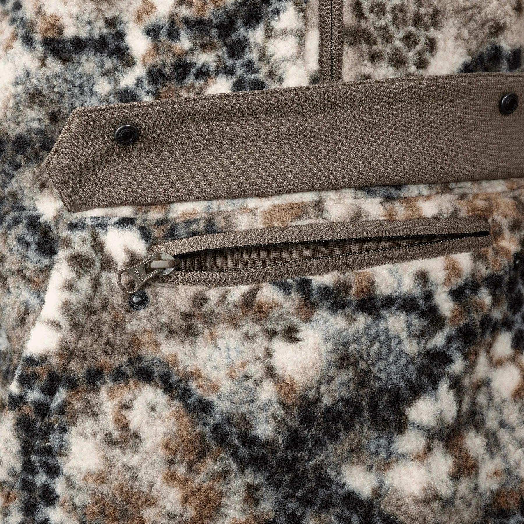 Close-up of camo fleece hoodie with brown pocket zipper and snap closure detail