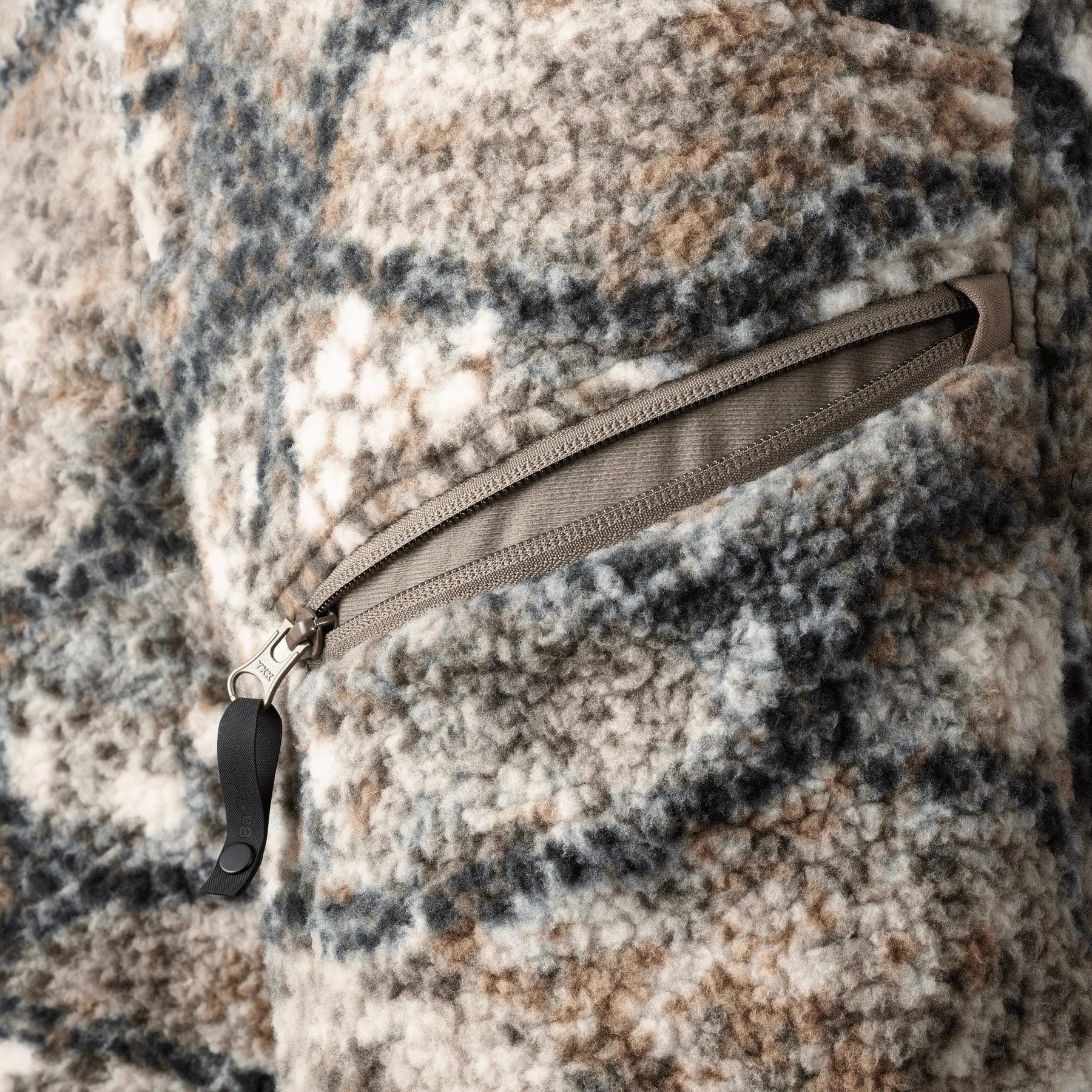 Close-up of Badlands Silens Pant fleece fabric with camo pattern and zippered pocket.