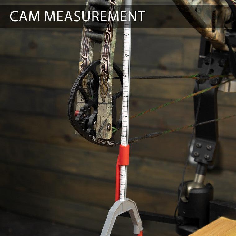 Archery bow cam measurement tool in use on compound bow, wood background