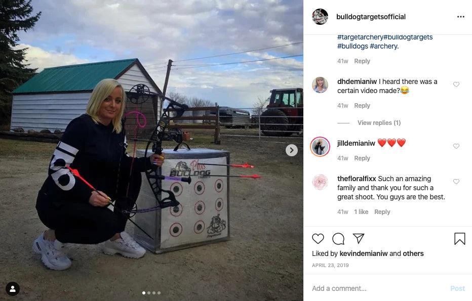 Woman kneeling by Bulldog Archery Doghouse FP target outdoors with compound bow and arrows.