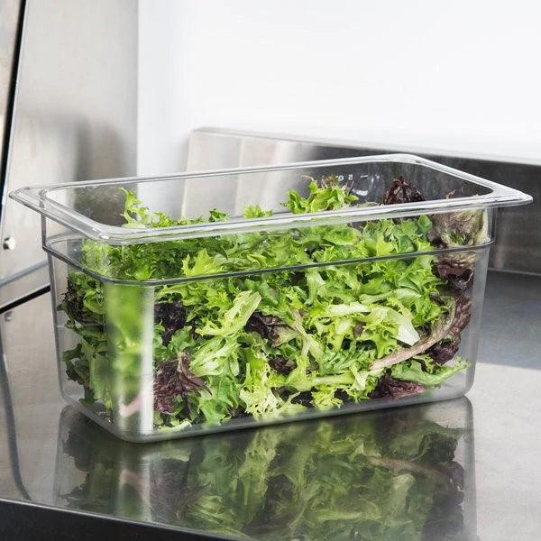 Catering pan with fresh mixed greens on stainless steel countertop