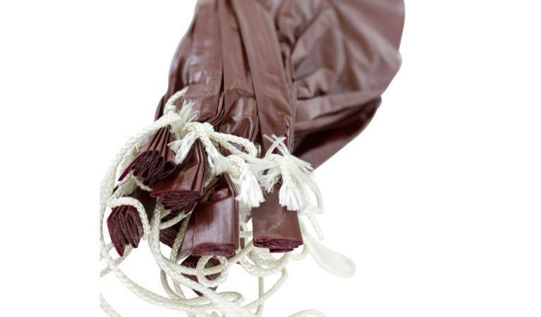 Bundle of brown chard fibrous sausage casings with white ties on a white background