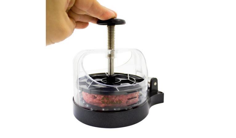 Hand pressing ground beef in a Chard burger press, kitchen tool on white background