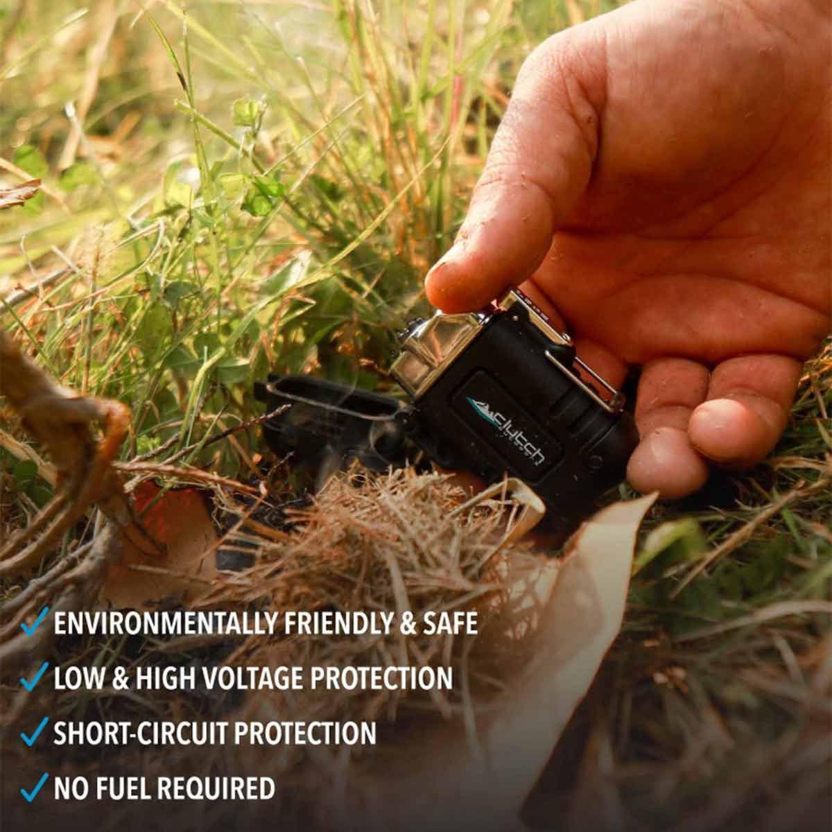 Hand using a waterproof rechargeable lighter outdoors in grass and dry twigs for camping
