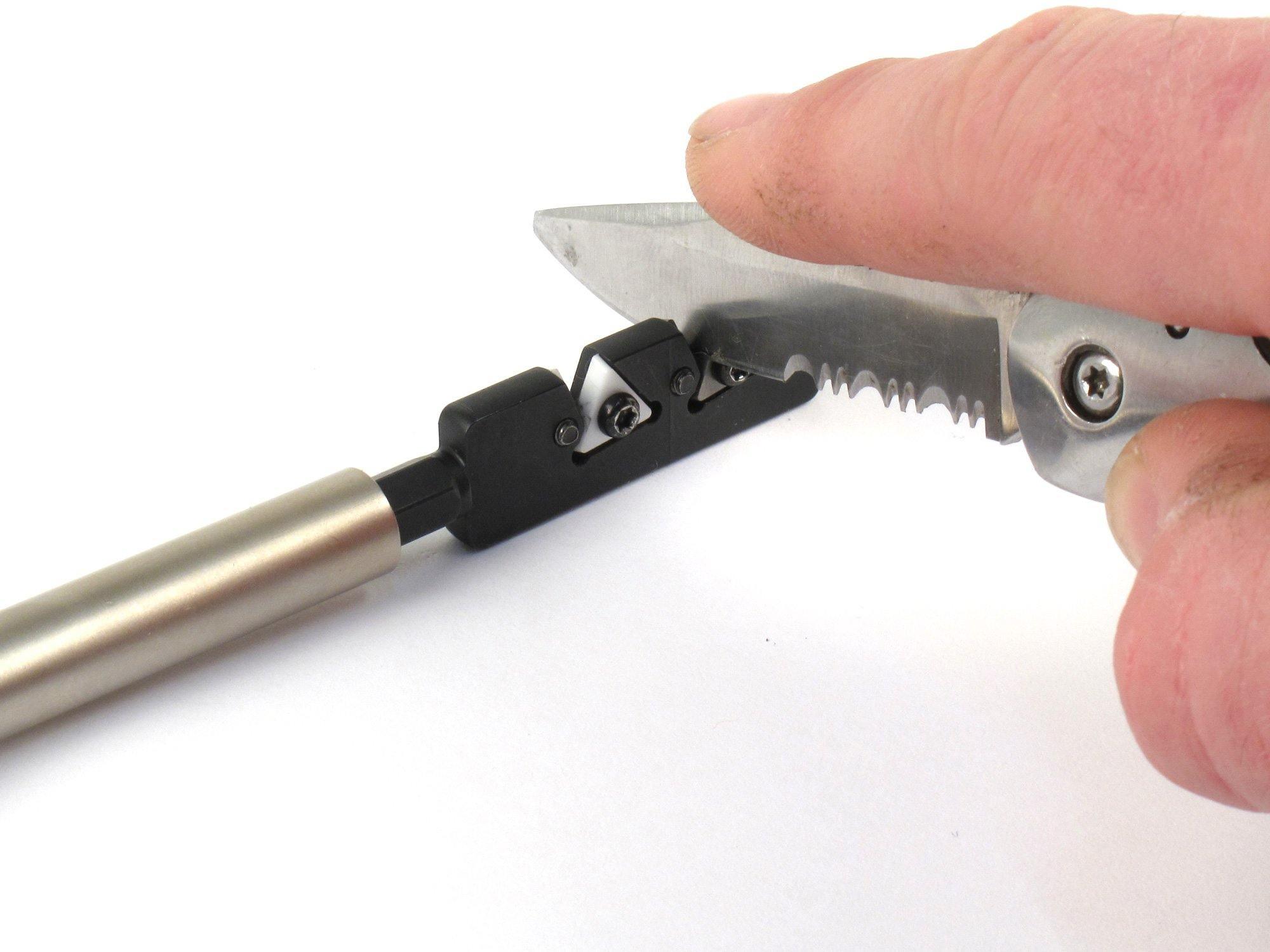 Hand using Fix It Sticks knife sharpener on a serrated folding knife against a white background