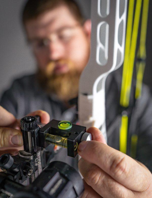 Person adjusting Hamskea Archery Gen2Pro third axis level on compound bow