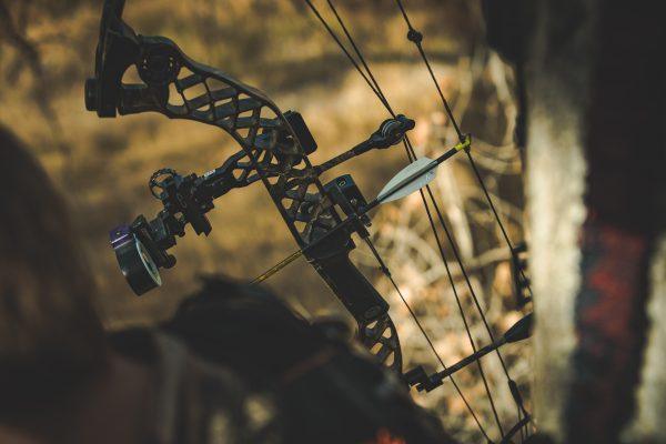 Hamskea compound bow with containment launcher in outdoor forest setting