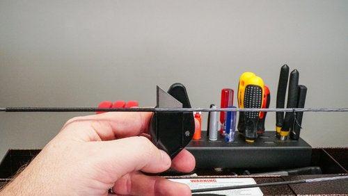 Hand holding Last Chance Archery Ready Blade arrow rest in front of tool organizer