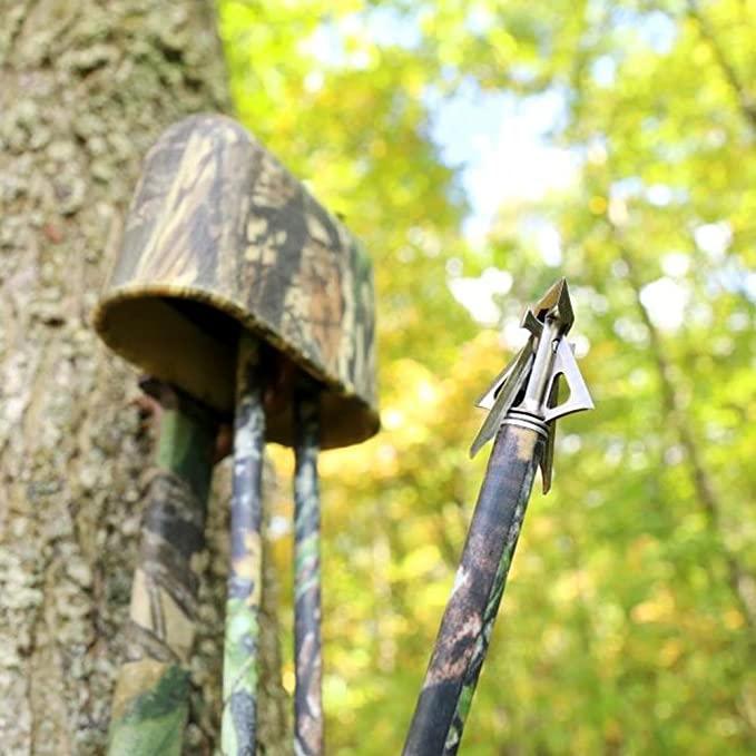 Muzzy broadhead arrow with camouflage quiver on a tree in forest for bow hunting