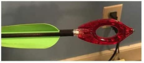 Nockturnal archery universal nock tool attached to arrow with green fletching indoors