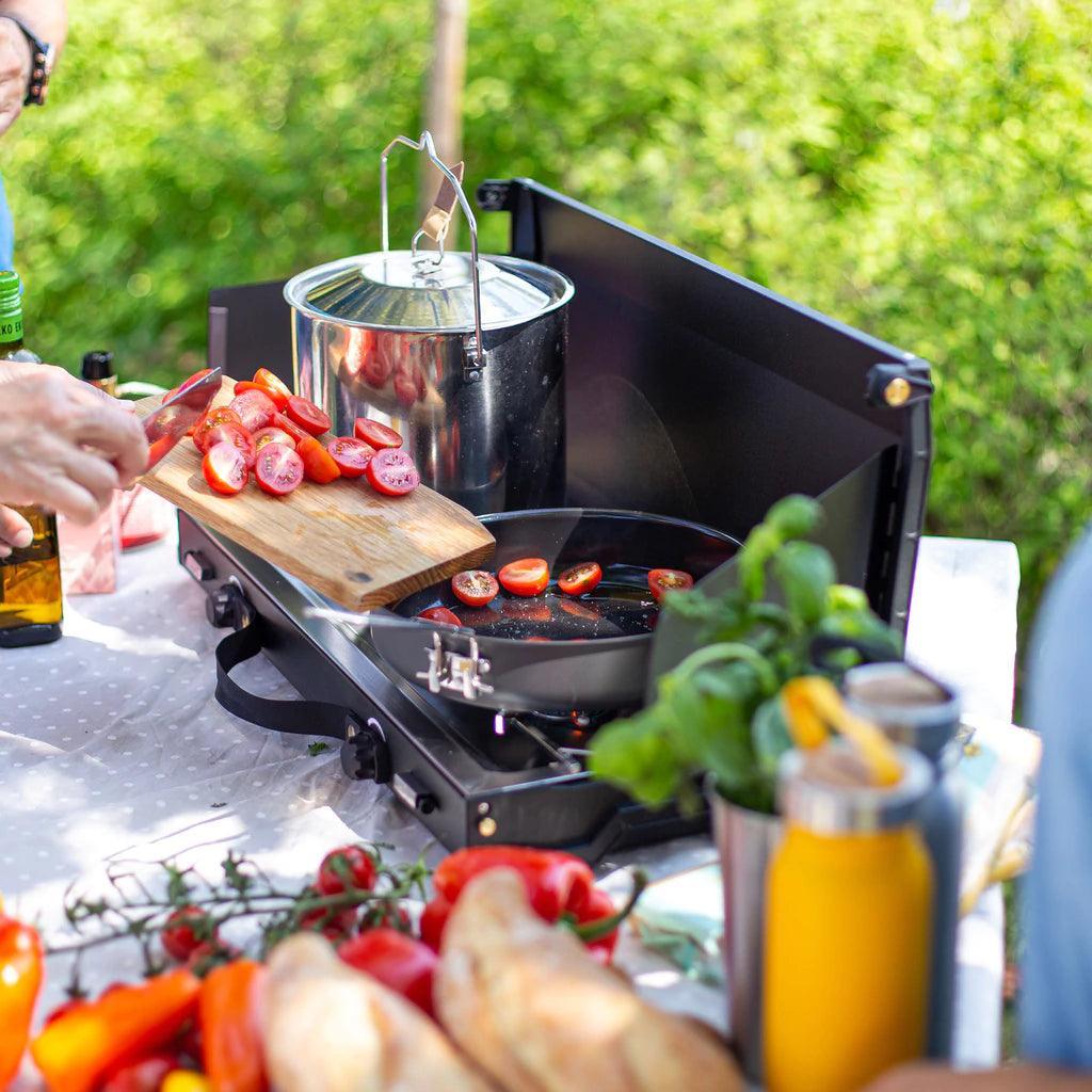Primus Alika stove outdoor cooking with fresh tomatoes and vegetables on picnic table