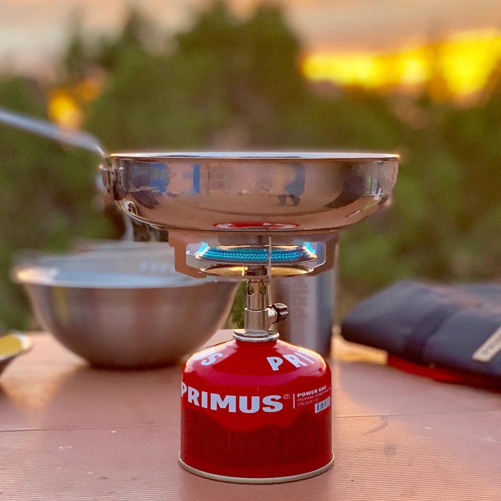 Primus campfire frying pan on portable gas stove outdoors at sunset
