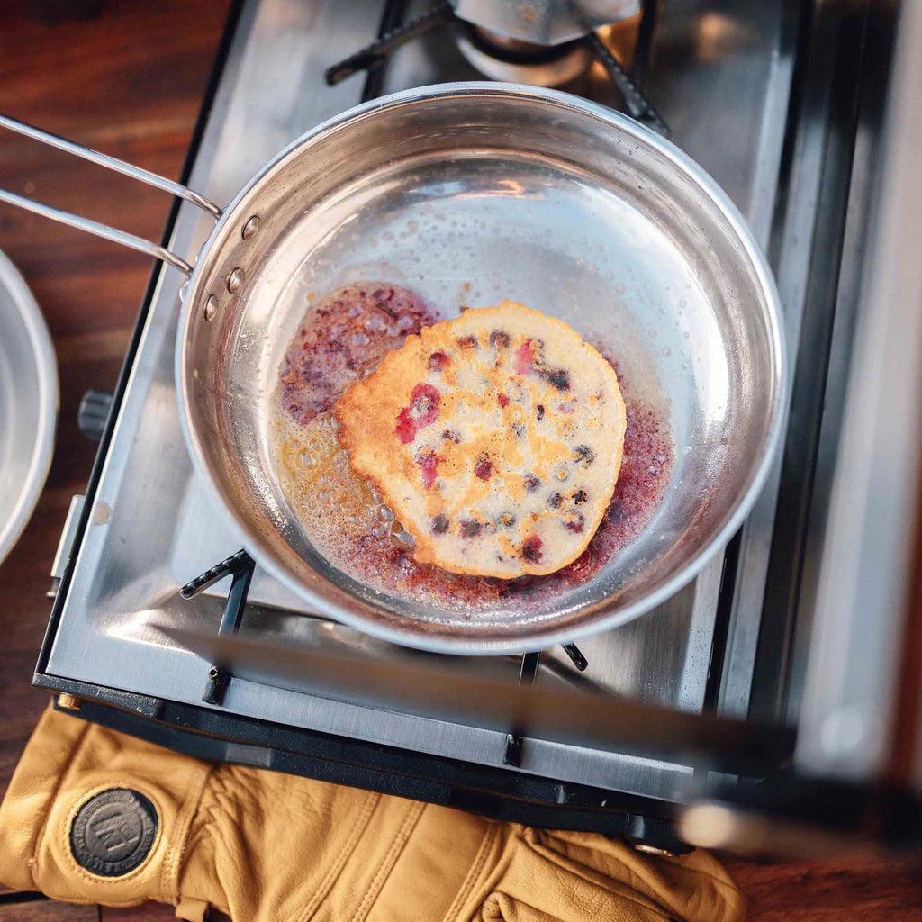 Primus Campfire stainless steel frying pan with pancake on outdoor gas stove
