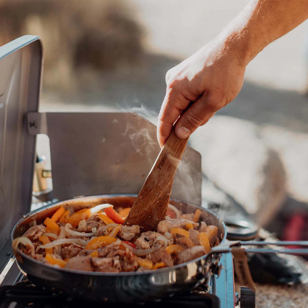 Cooking meat and vegetables in a Primus Campfire stainless steel frying pan outdoors