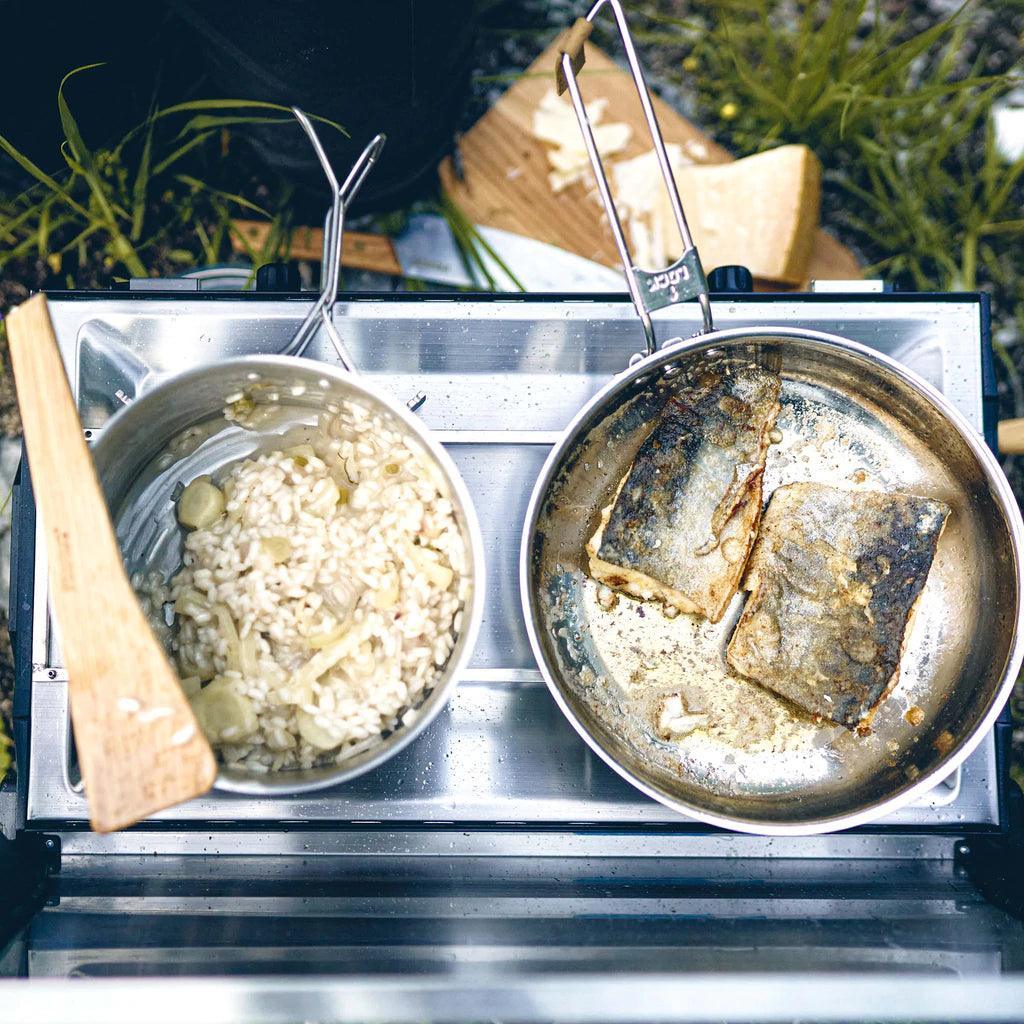 Primus campsite cookset on portable stove with rice and fish outdoors