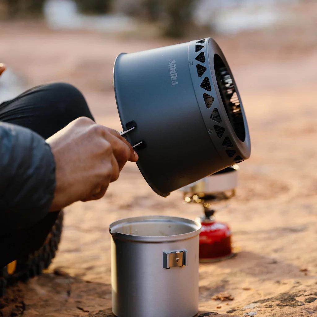 Primus campsite crimp pot gripper in use outdoors with cooking pot on dirt ground