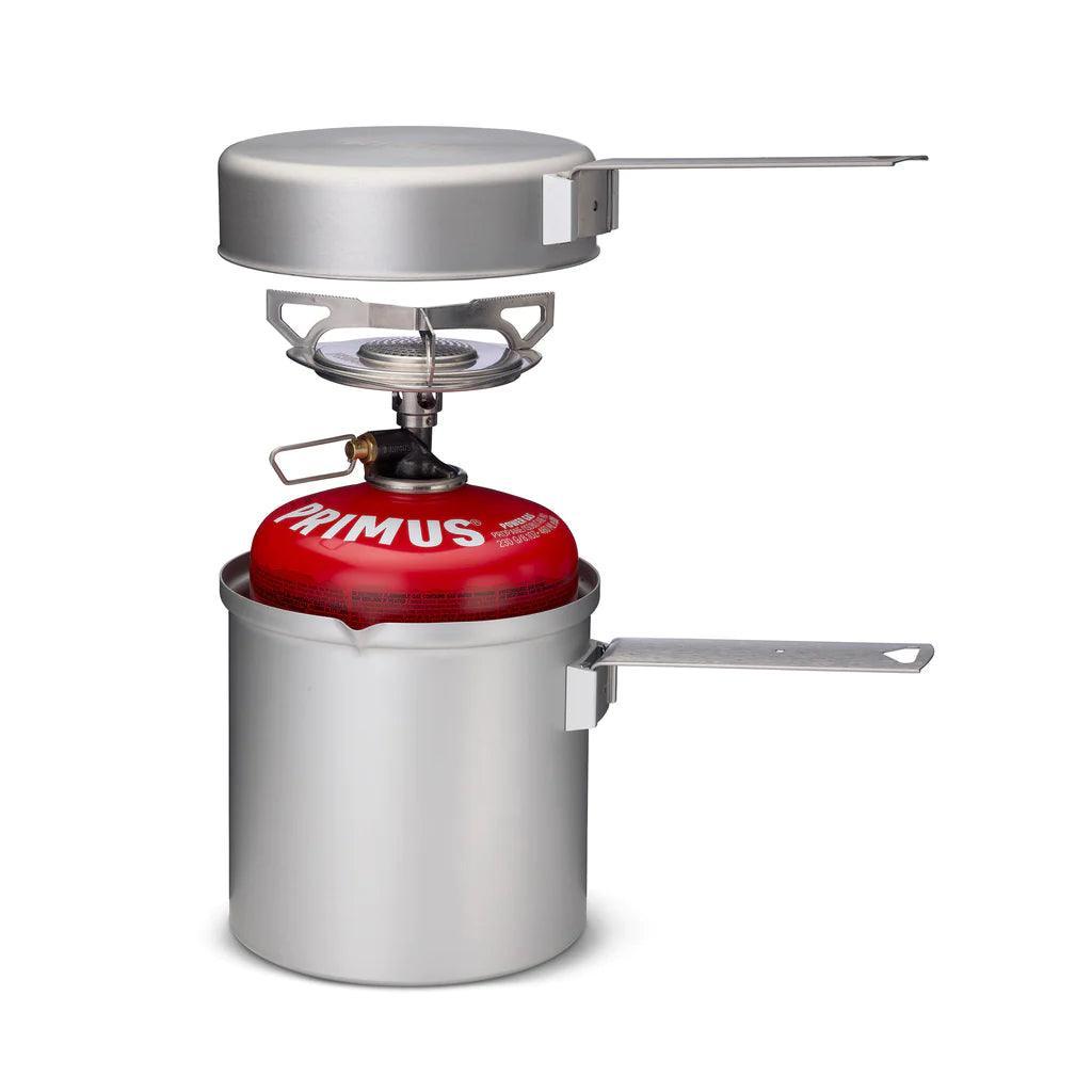 Primus camping stove kit with red fuel canister, pot, and pan for backpacking cooking