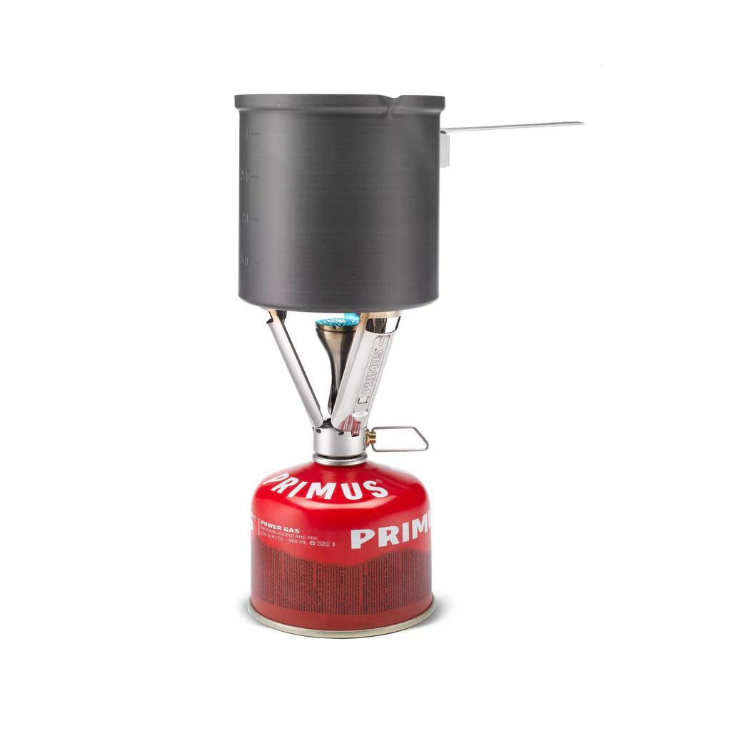 Primus backpacking stove with pot on red fuel canister, isolated on white background