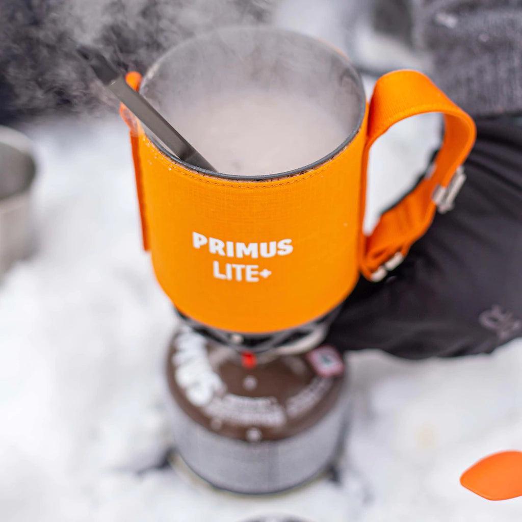 Primus Lite Plus stove system with orange sleeve heating on snow outdoors