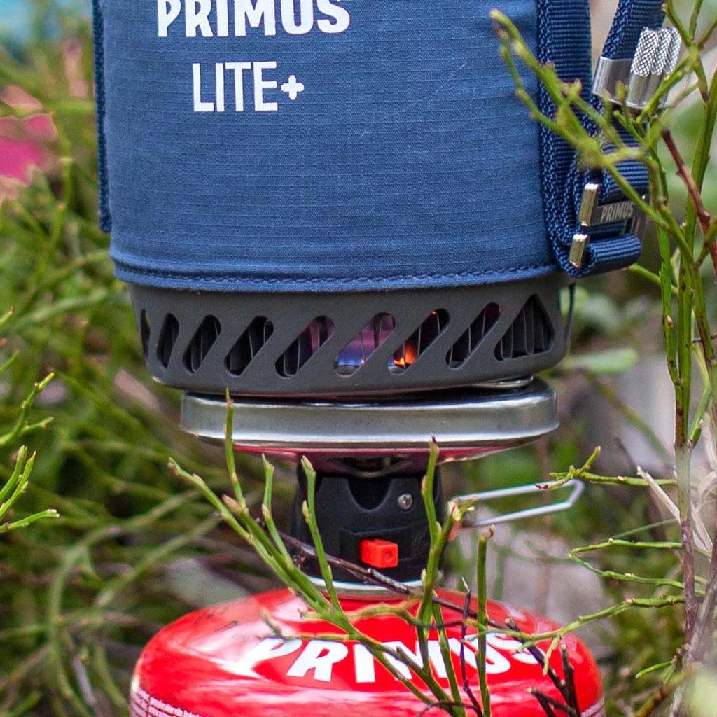Primus Lite Plus portable camping stove system outdoors with red fuel canister