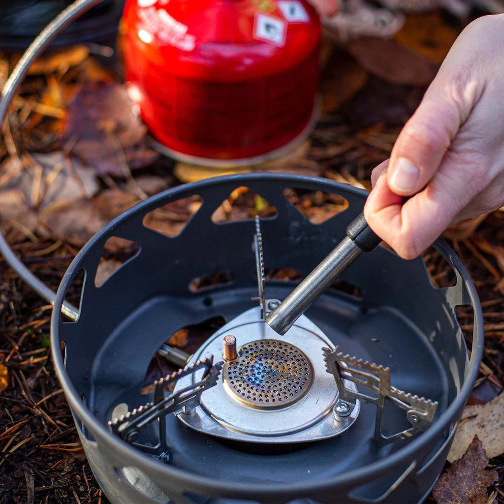 Lighting a Primus PrimeTech camping stove system outdoors on forest ground
