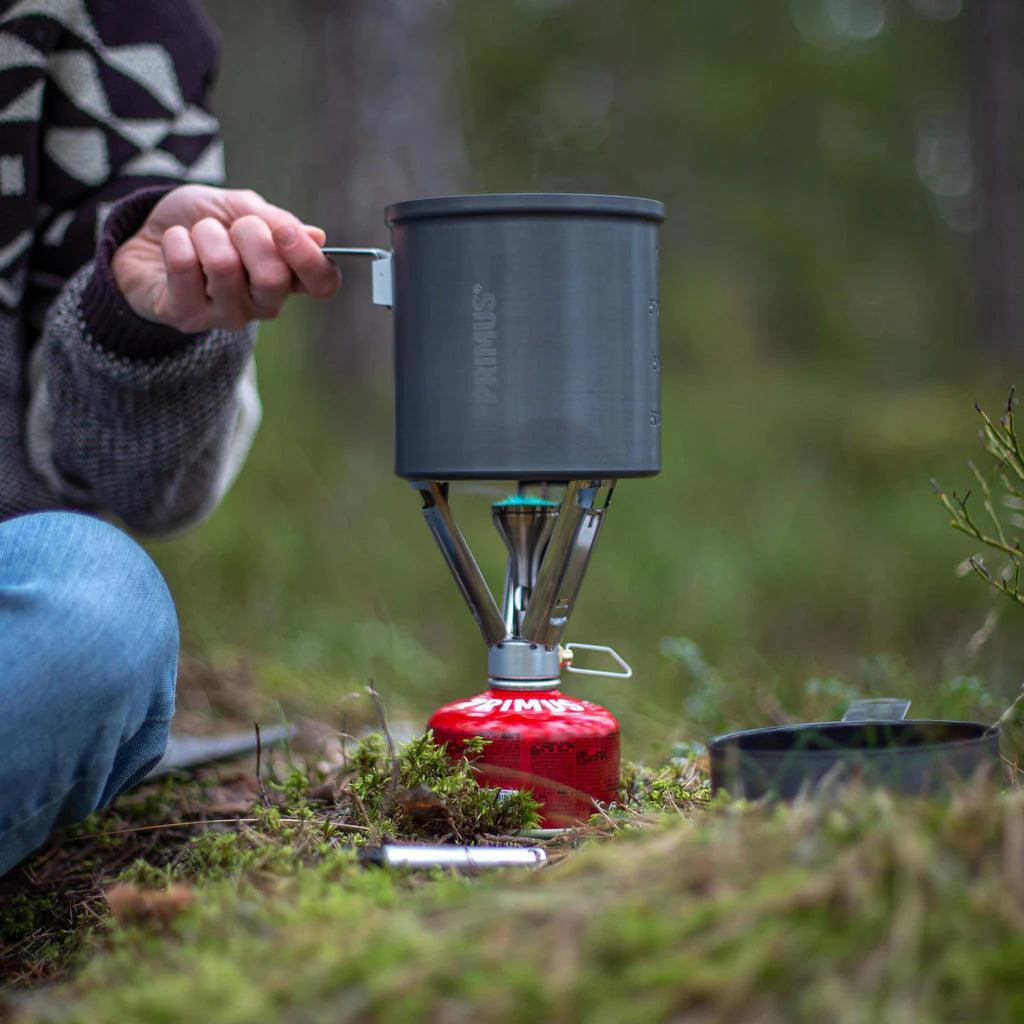 Primus Trek pot on portable camping stove outdoors in a forest setting
