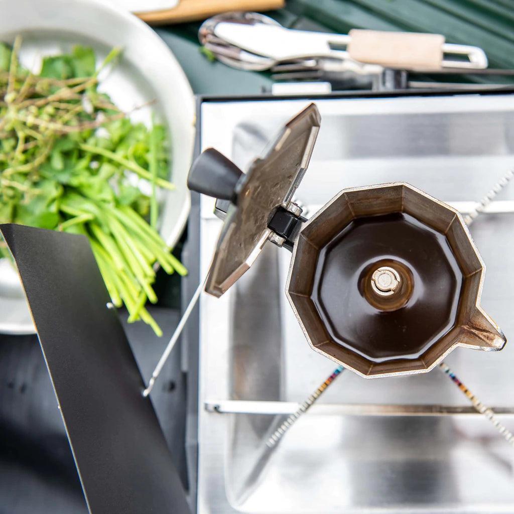 Primus Tupike camp stove with moka pot brewing coffee and fresh herbs nearby