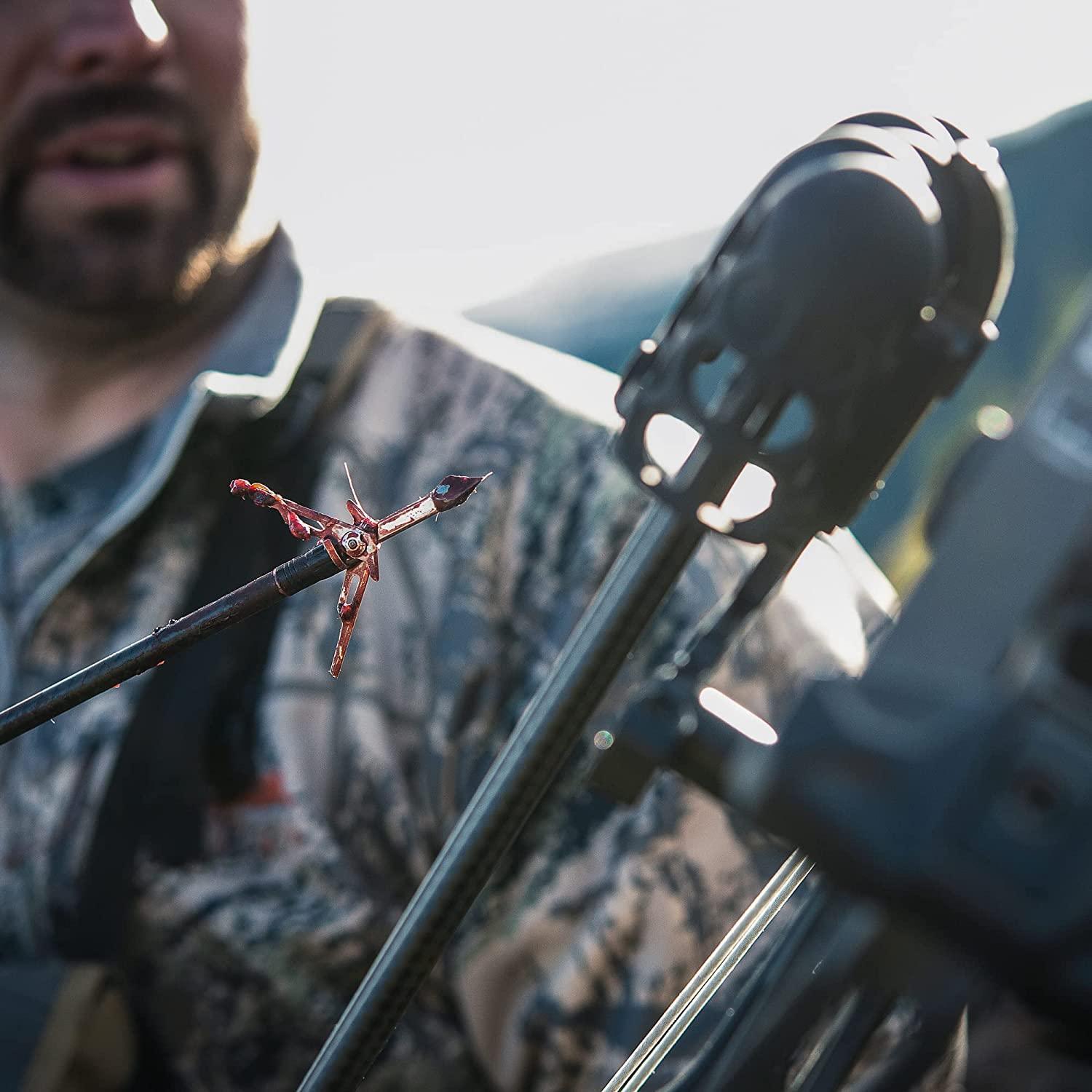 Close-up of a blood-covered SK2 broadhead arrow tip held by a camo hunter outdoors