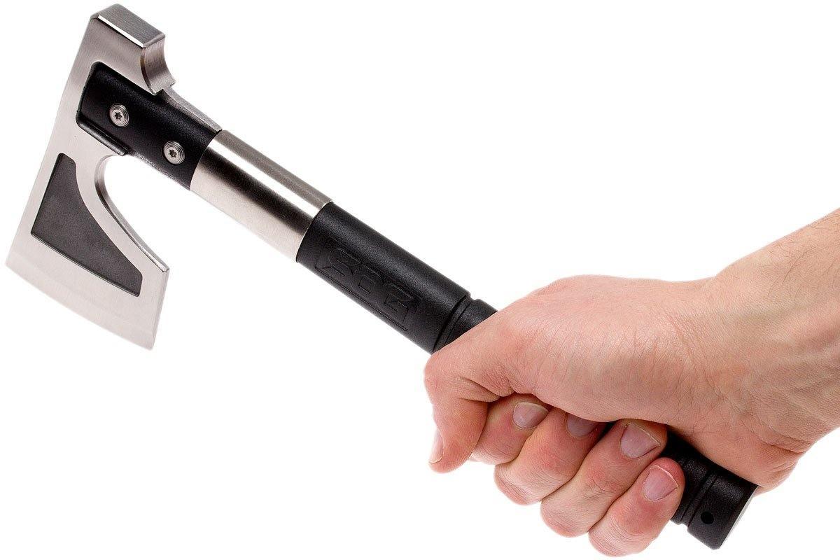 Hand holding SOG camp axe with black handle and silver blade on white background