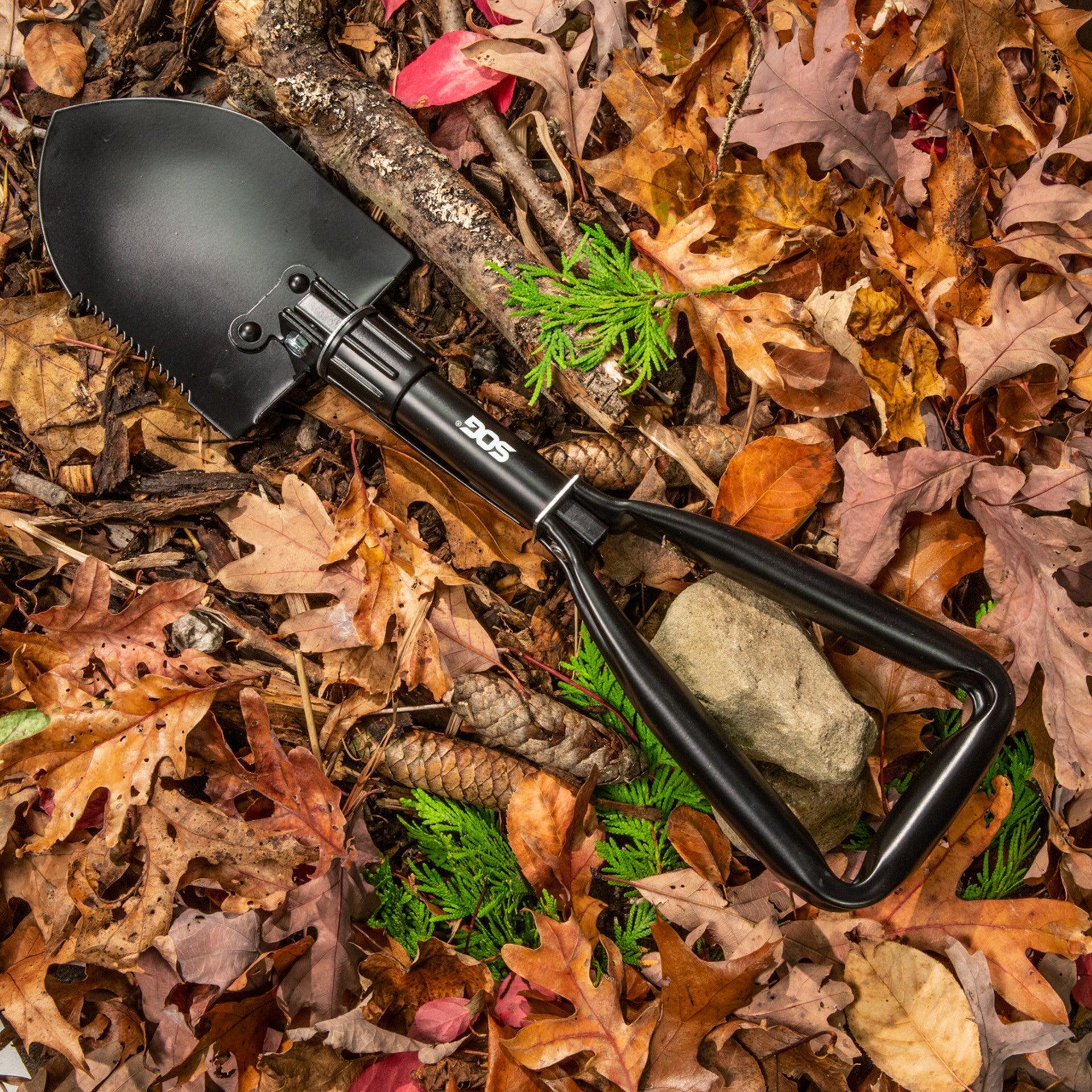 SOG entrenching tool folding shovel on autumn forest floor with leaves and rocks
