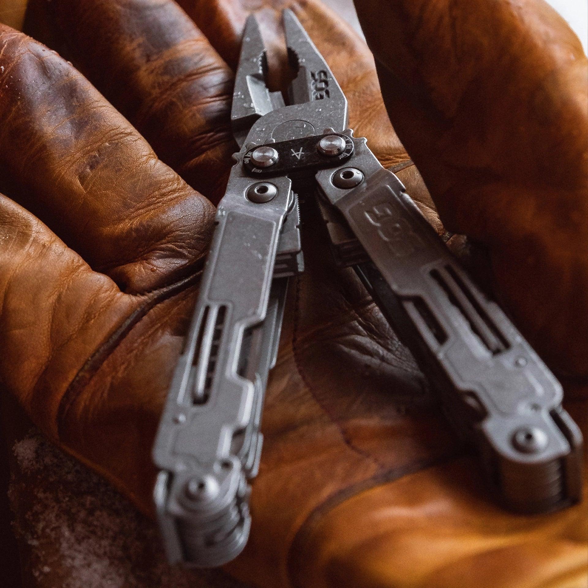 SOG PowerAccess Deluxe multi-tool resting on brown leather gloves