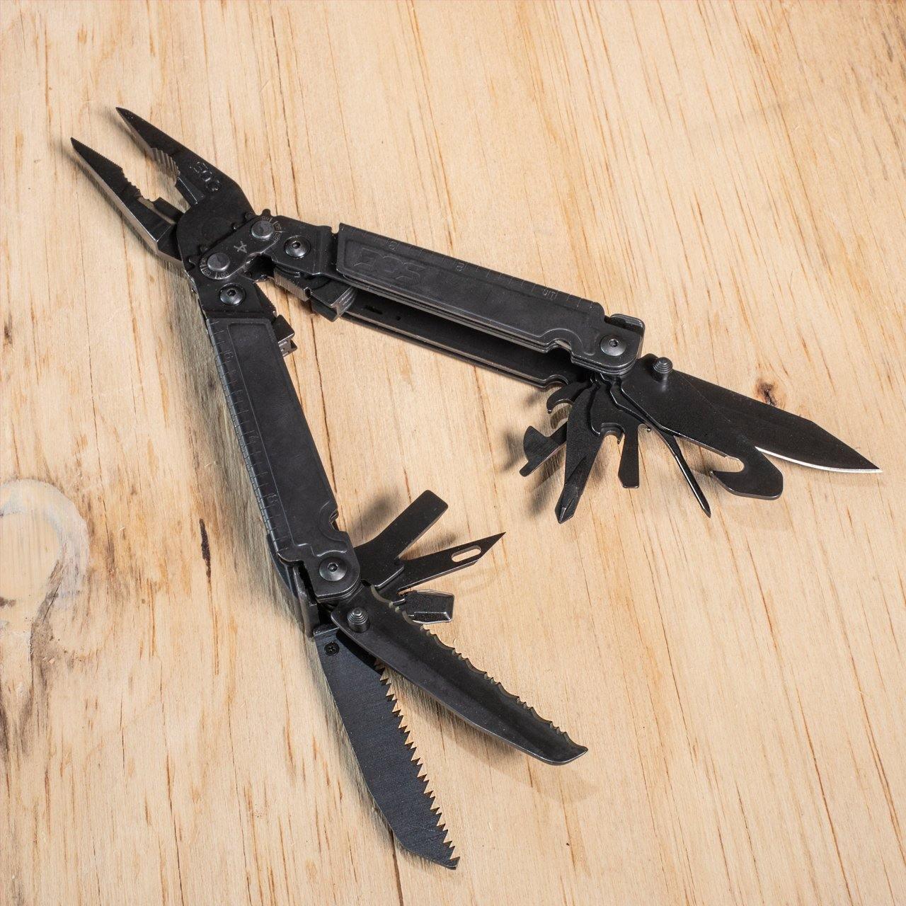 Black multitool with pliers, knife, and saw open on wood surface