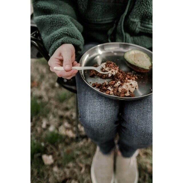 Person eating outdoors with Stansport stainless steel camping cutlery and plate on their lap