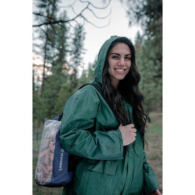 Woman in green rain suit with Stansport backpack in forest outdoors